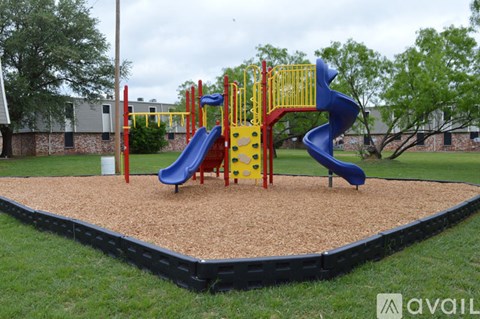 A playground with a blue slide and yellow and red play structures.
