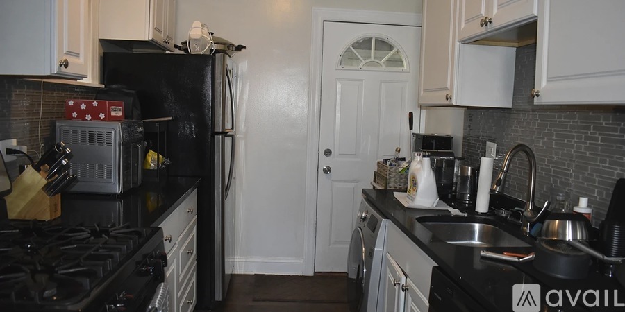 A modern kitchen with white cabinets and stainless steel appliances.