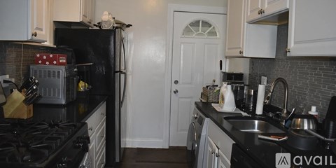 A modern kitchen with white cabinets and stainless steel appliances.