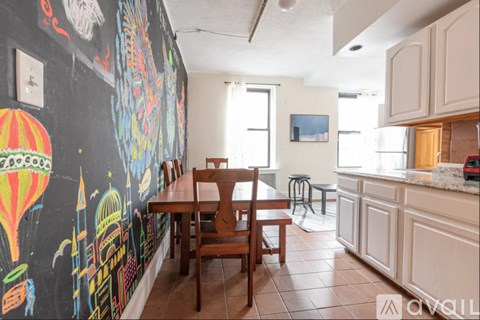 A kitchen with a table and chairs in front of a wall with a mural.