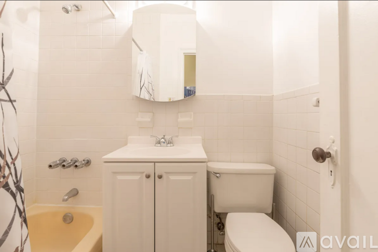 A white bathroom with a toilet, sink, and bathtub.