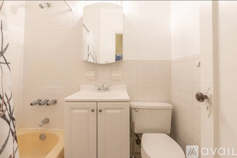 A white bathroom with a toilet, sink, and bathtub.