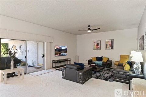 A living room with a black couch and a television.