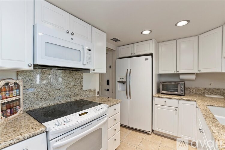 A kitchen with white cabinets and appliances.