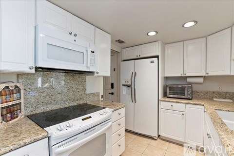 A kitchen with white cabinets and appliances.