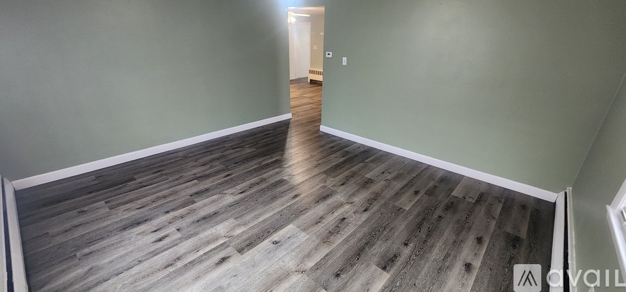 A room with wooden floors and two windows.