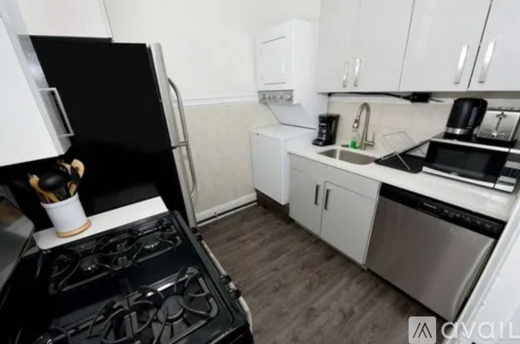 A black stove top oven in a kitchen with white cabinets.