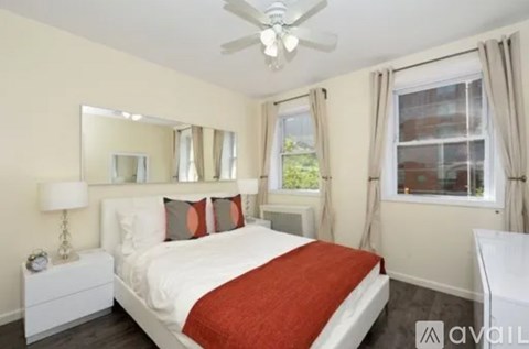 A bedroom with a bed, nightstand, and window.