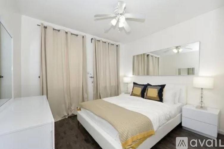 A bedroom with a bed, nightstand, and a ceiling fan.