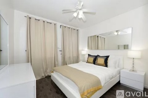 A bedroom with a bed, nightstand, and a ceiling fan.