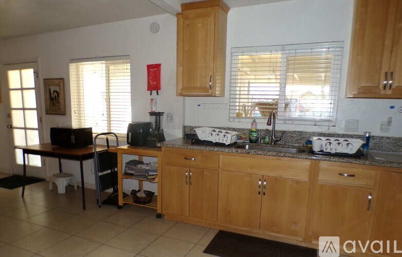A kitchen with wooden cabinets and a black mat on the floor.