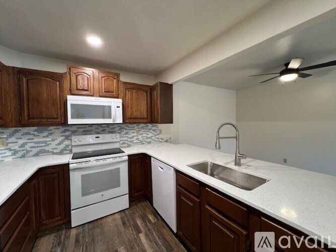A kitchen with wooden cabinets and white appliances.