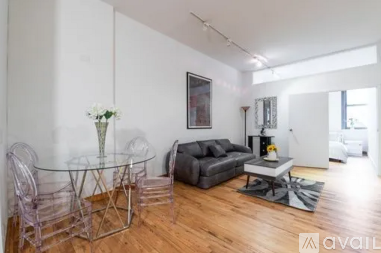 A living room with a glass table and a grey couch.