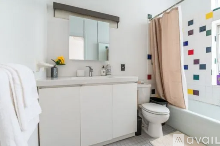 A white bathroom with a toilet, sink, and mirror.