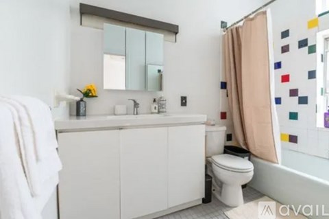 A white bathroom with a toilet, sink, and mirror.