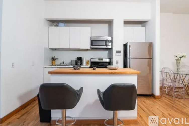 A kitchen with a refrigerator, microwave, toaster, and sink.