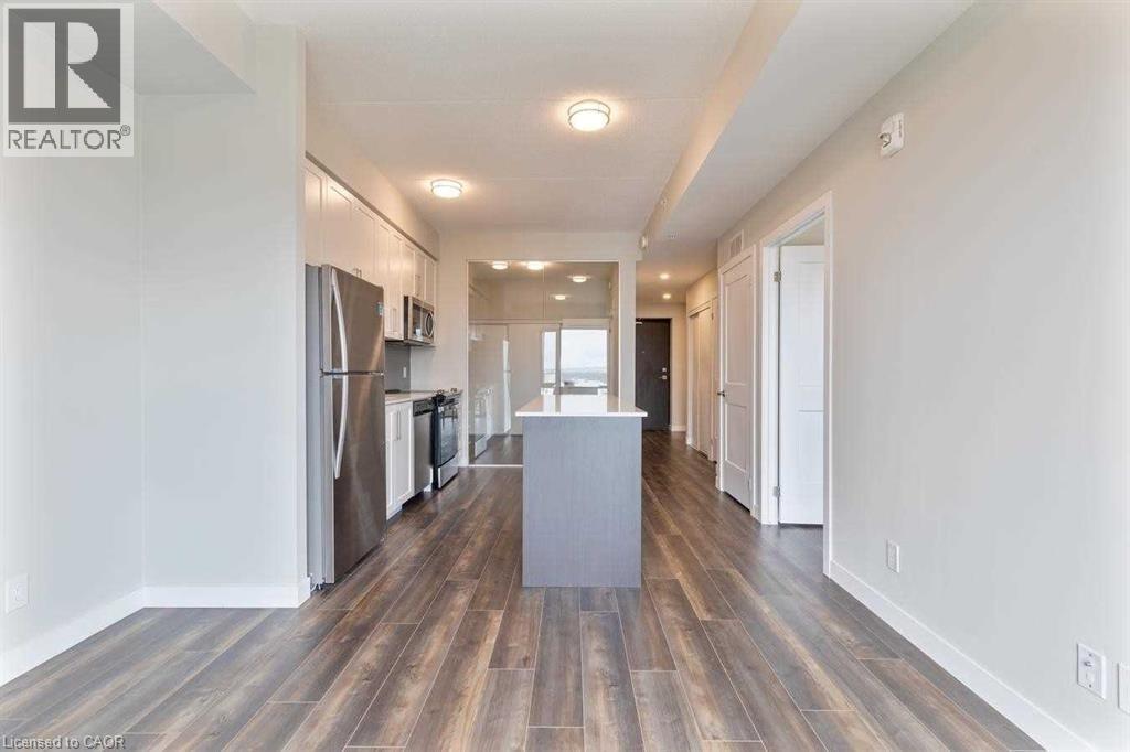 A spacious kitchen with wood flooring and a central island.