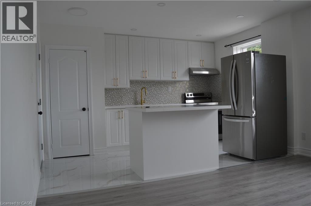 A kitchen with white cabinets and a black refrigerator.