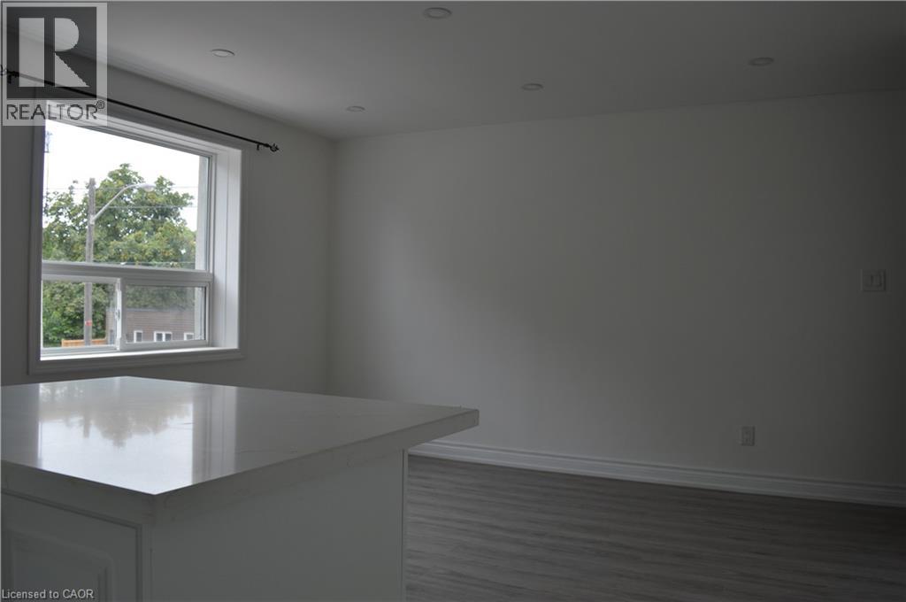 A realtor's office with a large window overlooking a tree-filled street.