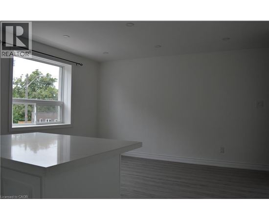 A realtor's office with a large window overlooking a tree-filled street.