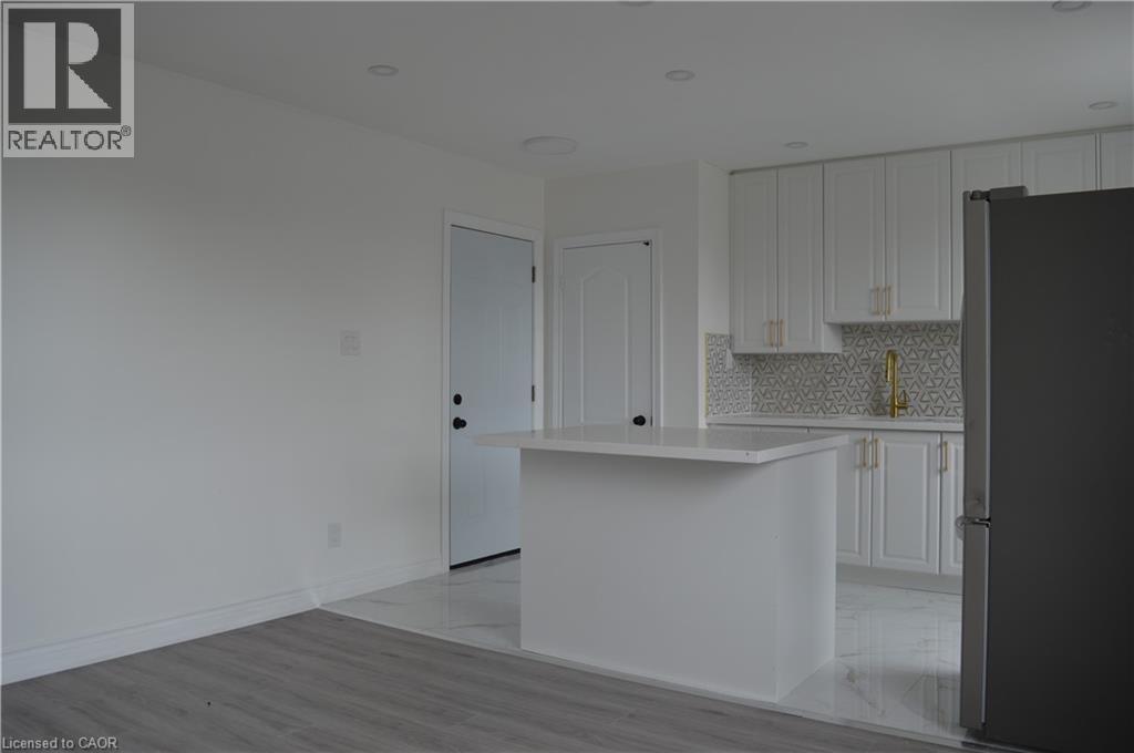 A white kitchen with a black refrigerator.