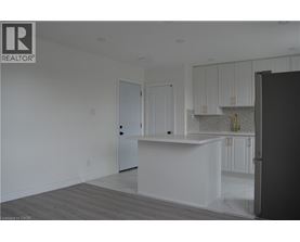 A white kitchen with a black refrigerator.