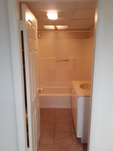 A small bathroom with a tub, sink and toilet.