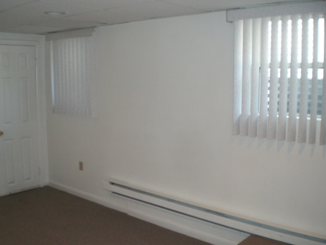 A room with a white door and a window with blinds.