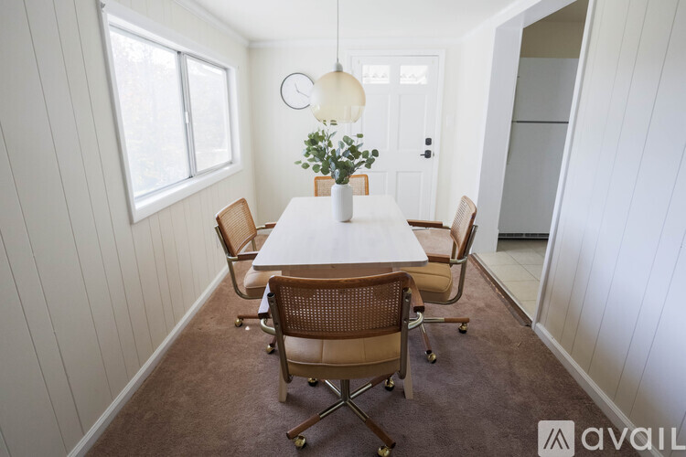 A dining room with a white table and chairs.