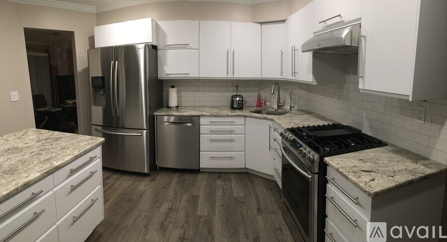 A kitchen with white cabinets and stainless steel appliances.