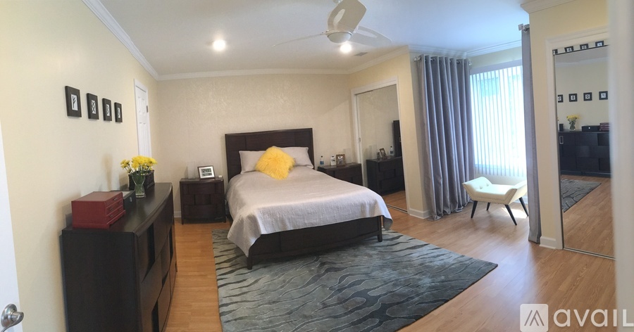 A bedroom with a bed, dresser, and mirror.