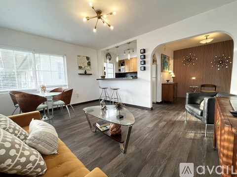 A living room with a brown sofa and a glass coffee table.