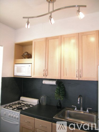 A kitchen with wooden cabinets and a black countertop.