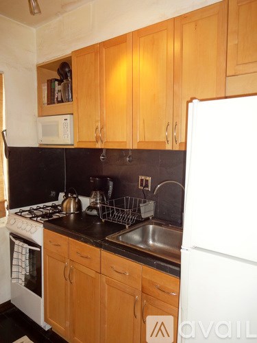 A kitchen with wooden cabinets and a white fridge.