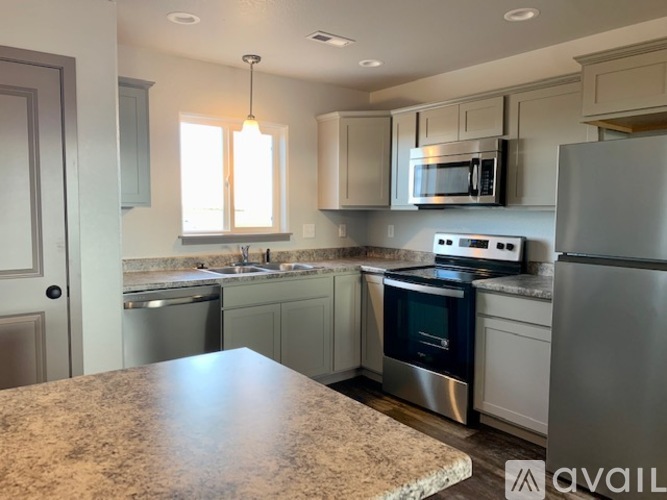 A kitchen with granite countertops and stainless steel appliances.