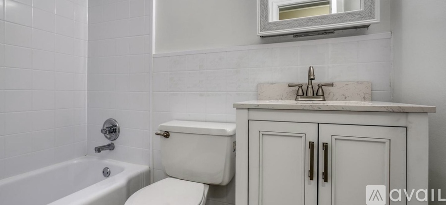 A white bathroom with a toilet, sink, and tub.