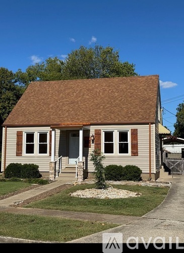 A small house with a brown roof and a front porch.