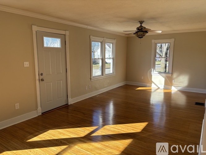 A room with wooden floors and a ceiling fan.