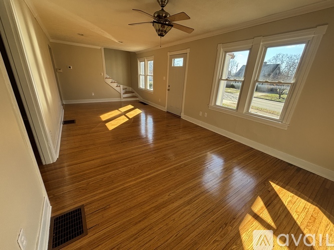 A room with wooden floors and a ceiling fan.