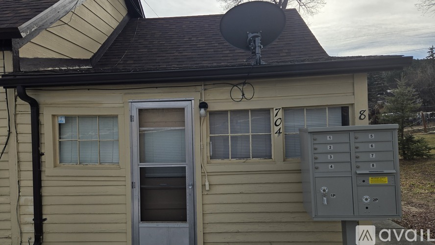 A house with a satellite dish on the roof and a utility box on the side.
