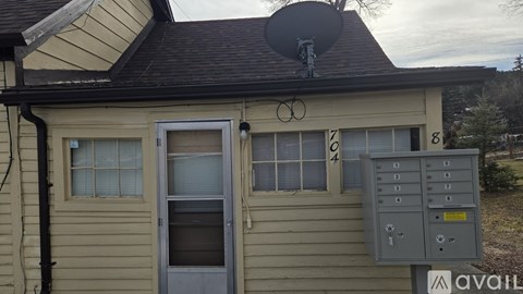 A house with a satellite dish on the roof and a utility box on the side.