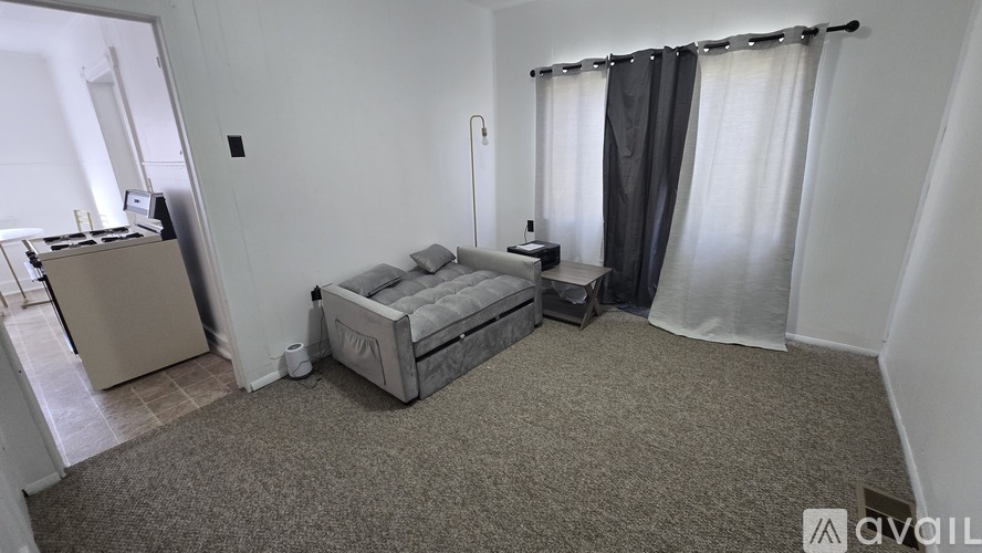 A room with a bed, a cabinet, and a carpet.