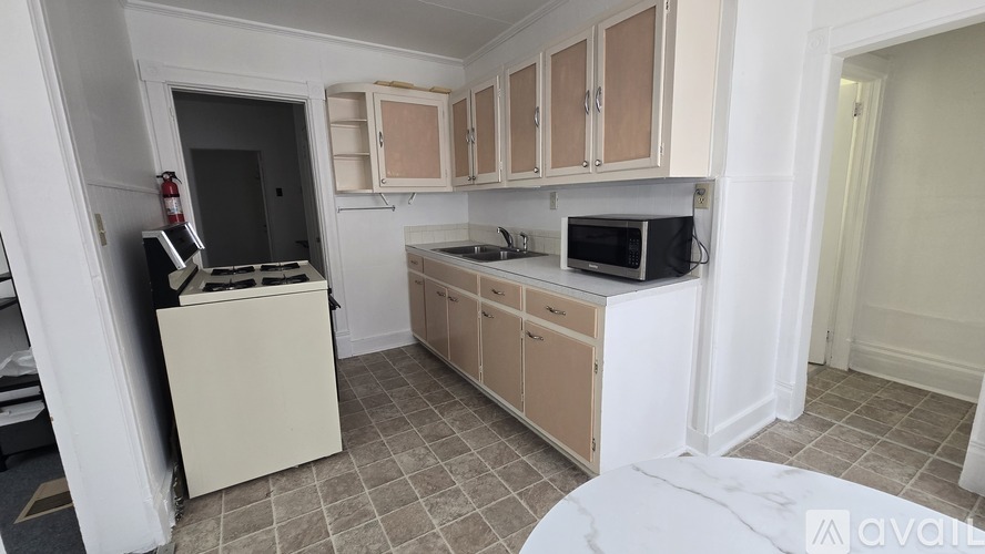 A kitchen with white cabinets and a black stove top oven.