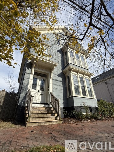 A house with a grey facade and white trim is shown.