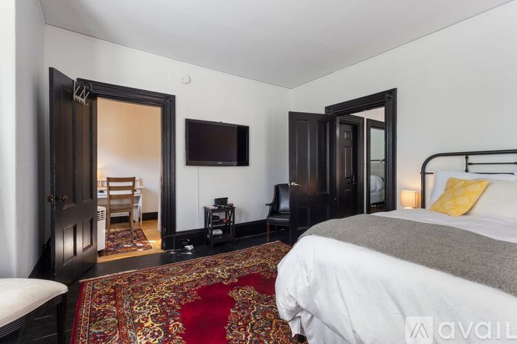 A bedroom with a large bed and a television on the wall.