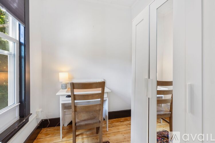 A room with a table and chairs and a window.