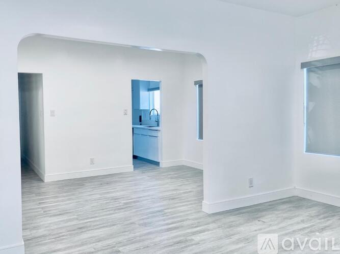 A spacious room with a door leading to another room.