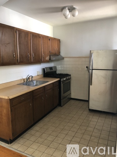 A kitchen with a refrigerator, sink, and stove.