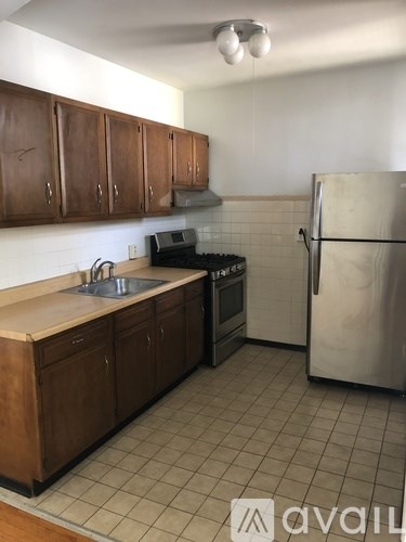 A kitchen with a refrigerator, sink, and stove.