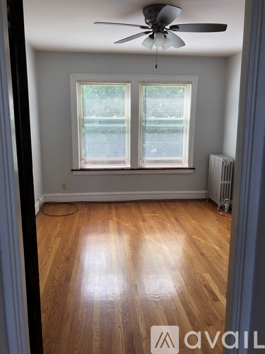 A room with a ceiling fan and a window.